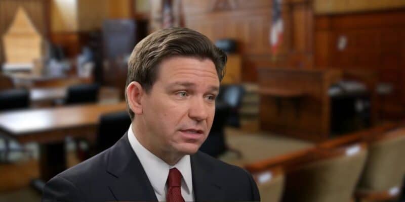 Ron DeSantis speaking within a courtroom setting.