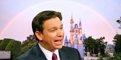 DeSantis smiling with an iconic fairy tale castle and a rainbow in the background.