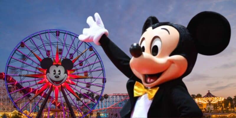 Mickey mouse waving in front of a colorful ferris wheel with mickey mouse design.