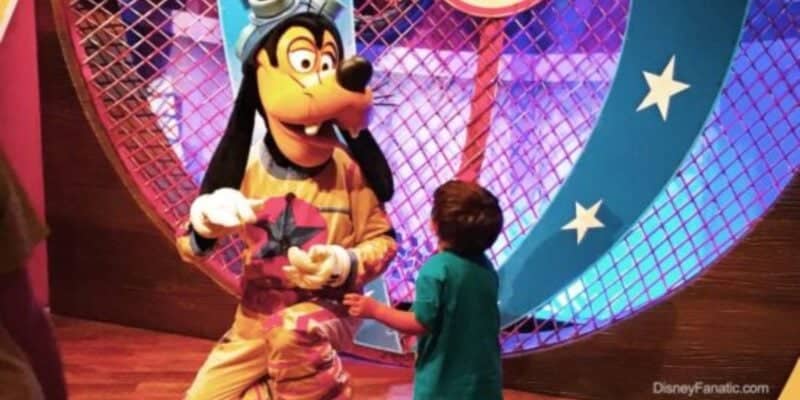 A child runs up to hug a Disney Character Performer portraying Goofy at Pete's Silly Sideshow in Magic Kingdom at Walt Disney World.