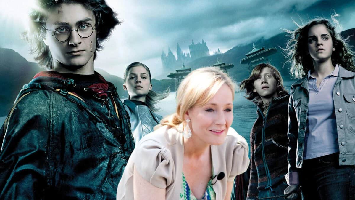 JK Rowling in front of a promotional picture for 'Harry Potter,' including Harry, Ron, Hermione, and Fleur