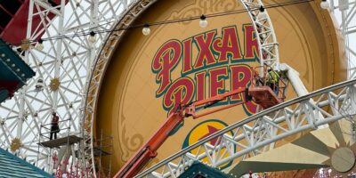 Construction cast members work on the Incredicoaster loop, removing part of the track.