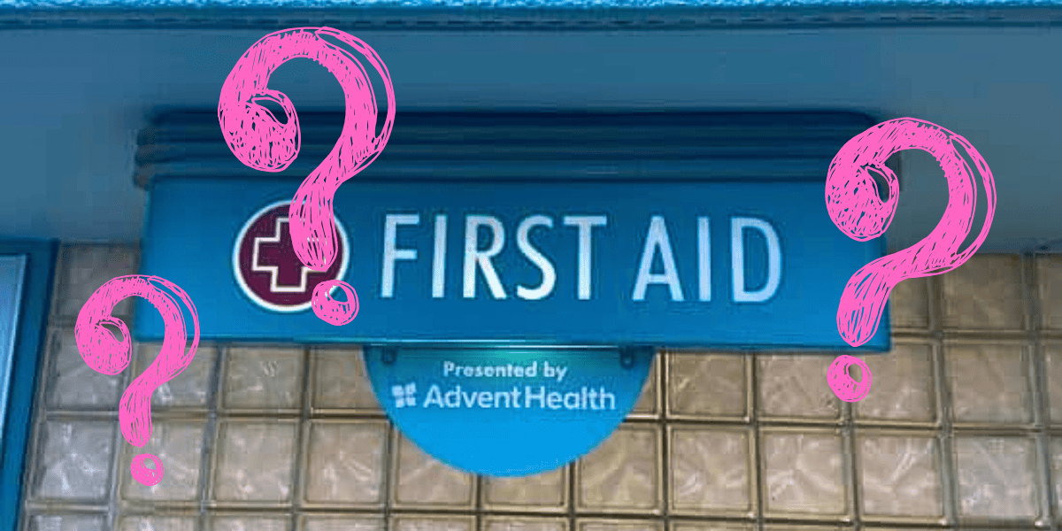 A blue "first aid" sign with pink question marks drawn over it. the sign is presented by adventhealth and mounted on a wall with a block glass pattern.