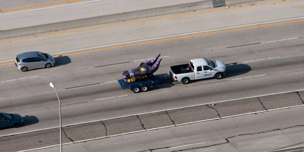 A purple Maleficent head getting pulled down the highway by a white truck as one of many Disney props spotted outside the resort.
