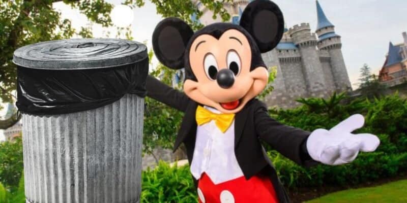 Mickey mouse greeting visitors with a warm welcome beside a trash can at a theme park, with a castle visible in the background.