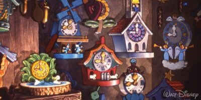 A colorful assortment of variously styled cuckoo clocks hanging on a wooden wall, each featuring unique designs and characters, from disney's animated environment.