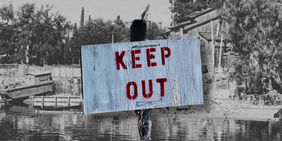 A black and white photo of the Rivers of America at Disneyland. A sign reading "keep out" is superimposed in the foreground.