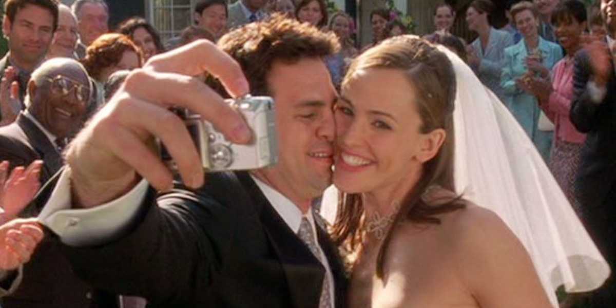 Jennifer Garner as Jenna and Mark Ruffalo as Matty happily taking a selfie with a small camera, with guests in the background smiling and clapping at their wedding ceremony.
