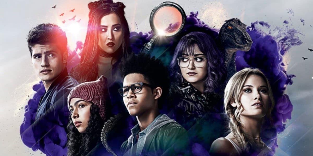A group of six young people with serious expressions stands against a colorful, misty background. Each person has a distinct style, from casual to goth. An ominous ring and a dinosaur are also visible in the background, adding a mysterious atmosphere.