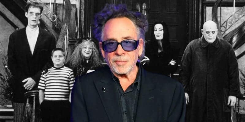 Tim Burton stands in front of a backdrop featuring iconic characters from "Wednesday," illustrating his creative influence on gothic and dark fantasy cinema.