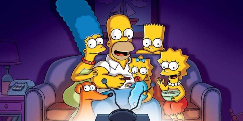 The Simpsons family—Homer, Marge, Bart, Lisa, and Maggie—sitting close together on a couch, joyfully watching TV in a dimly lit room.