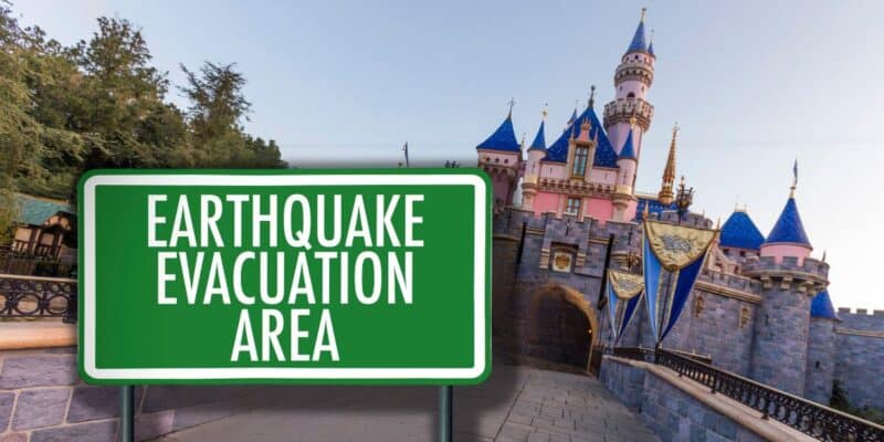 A sign reading "earthquake evacuation area" in front of a picturesque Disney castle with blue rooftops and golden accents under a clear sky.