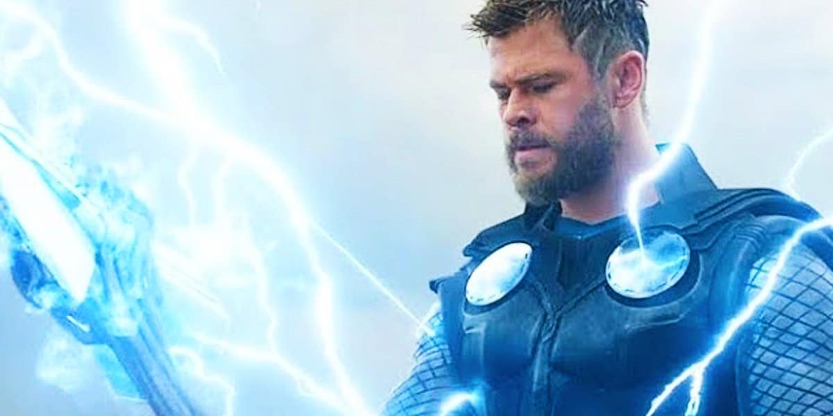Thor, portrayed by Chris Hemsworth, stands dramatically in his armor wielding an electrified axe against a glowing, misty blue background.