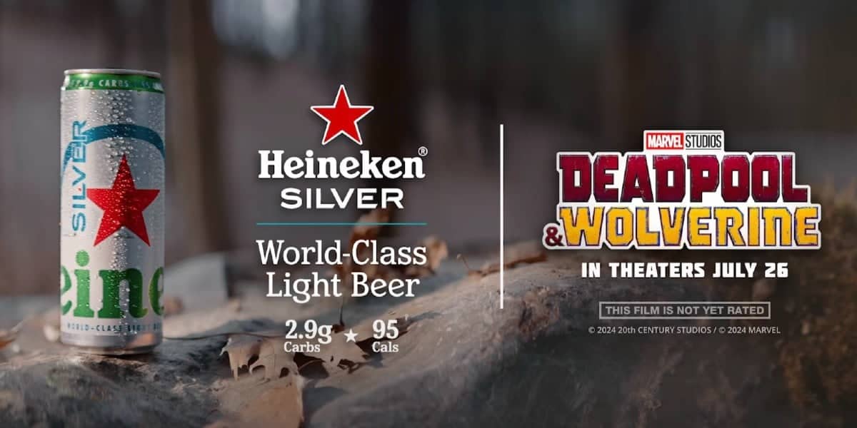 A can of Heineken Silver beer is on the left with its logo and "World-Class Light Beer" text beneath. On the right, there's a Marvel Studios "Deadpool & Wolverine" logo with the release date "In Theaters July 26." Nutritional info shows 2.9g carbs and 95 calories.