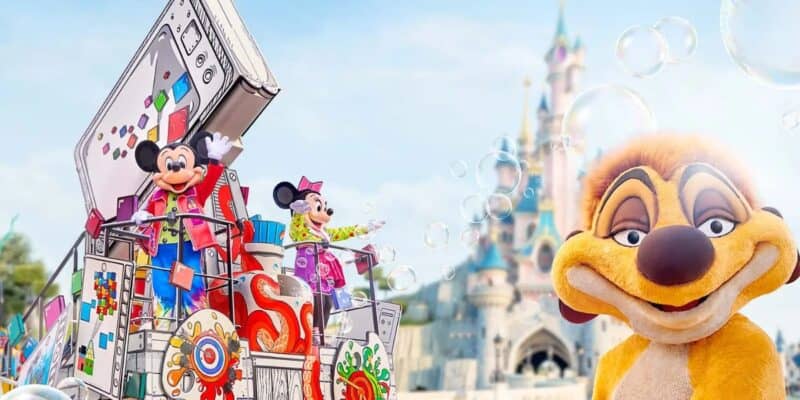 Mickey and Minnie Mouse wave from a colorful parade float adorned with various decorative art, while Timon smiles at the camera. In the background is a fairytale castle and bubbles floating in the air, creating a magical atmosphere.