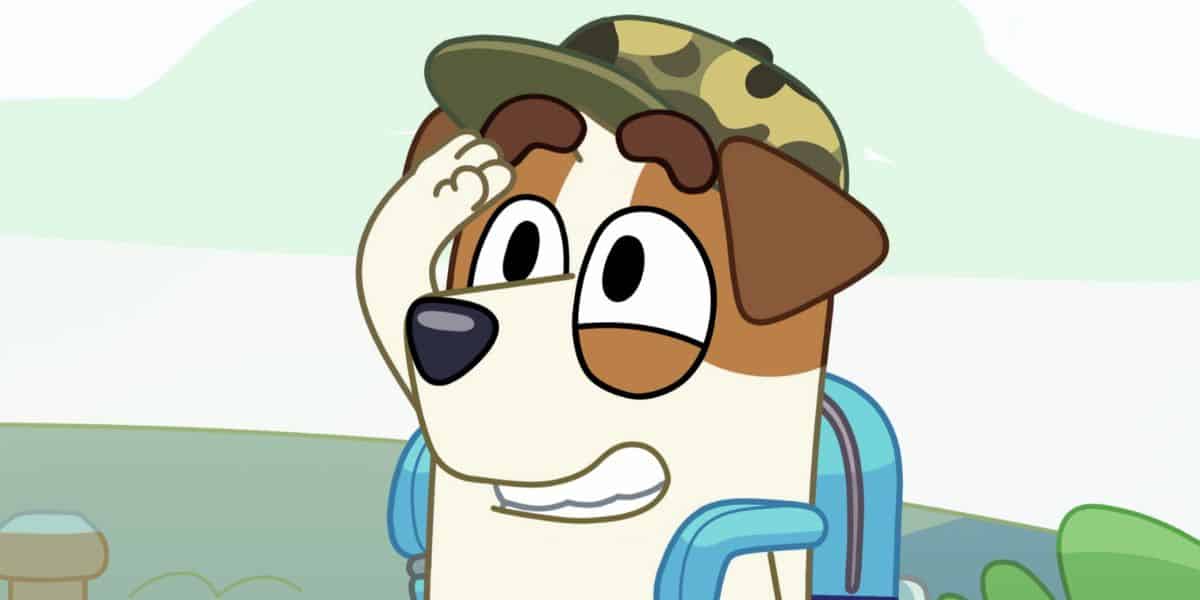 An animated dog character with brown and white fur, reminiscent of Bluey, wears a green camouflage hat and a blue backpack. The dog raises a paw to its head, appearing to salute. The background showcases a soft, stylized landscape with light greenery and an open sky.