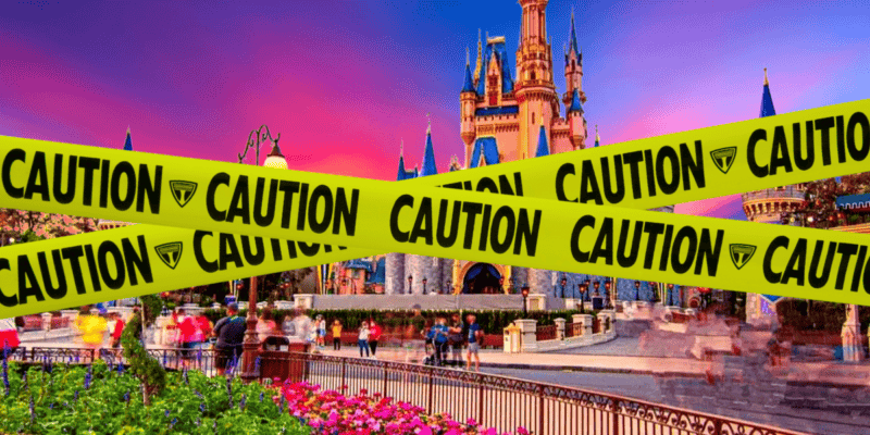 Image of a colorful castle at a theme park, with a bright pink and purple sky in the background. The foreground is obstructed by multiple yellow "caution: monkeys loose in Florida" tapes running