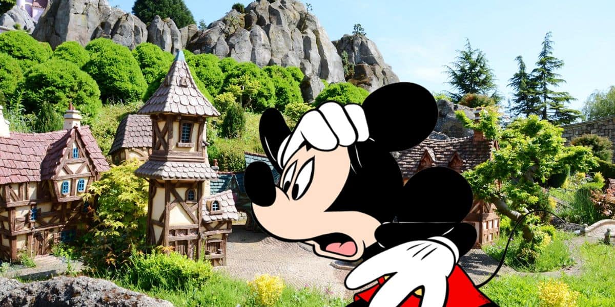 A vibrant image juxtaposing a miniature fairy tale village with quaint houses and sharp, rocky cliffs in the background, overlaid with a cartoon image of Mickey Mouse from Disney Parks in the foreground.
