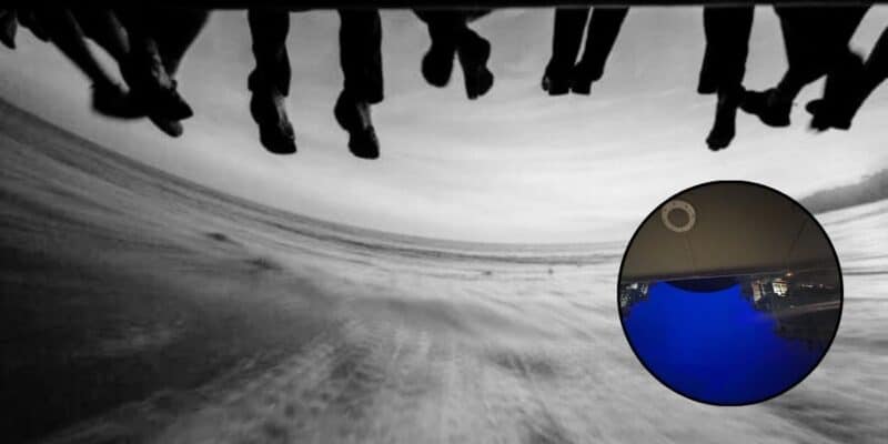 Feet dangling on Soarin' Over California in black & white, a photo of the blue screen on Soarin' Around the World.