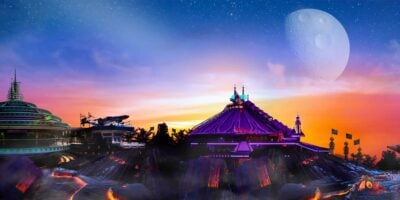 A vibrant, futuristic landscape at sunset featuring a neon-lit spaceship launch pad, a domed building with colorful lights, and a moon glowing in a star-filled sky. Smoke and glowing cracks in the ground add a dramatic touch to the scene with kids running in the park with their new Disney Park annual pass.