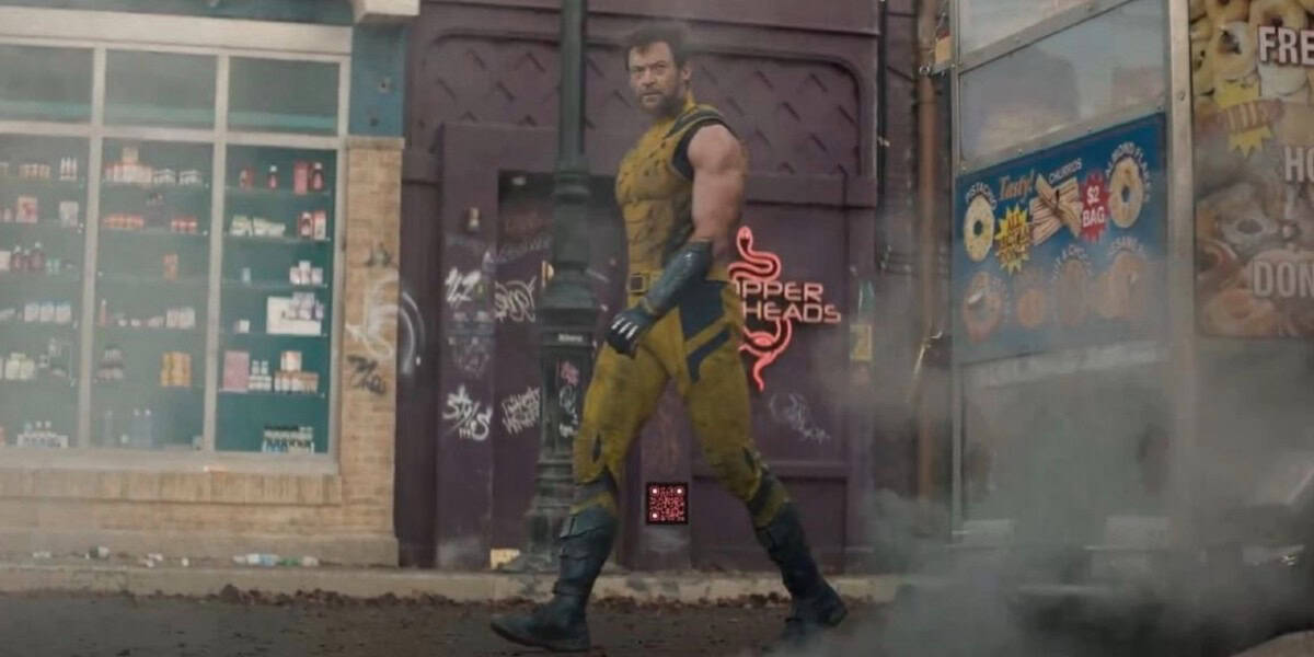 A muscular man in a yellow and blue costume stands on a gritty urban street. The background features a purple wall with the word "VIPER HEADS" and graffiti, a corner shop, and some vending machines. Smoke or mist partially obscures the ground.