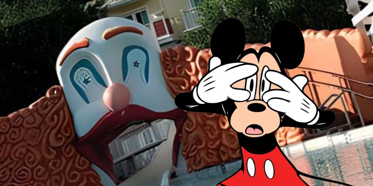 An animated character resembling a recognizable mouse figure is covering its eyes with its gloved hands, standing in front of a large clown face entrance at Disney World. The clown face has exaggerated features and a wide-open mouth, creating what looks like a nightmare experience for the hotel guest watching nearby.