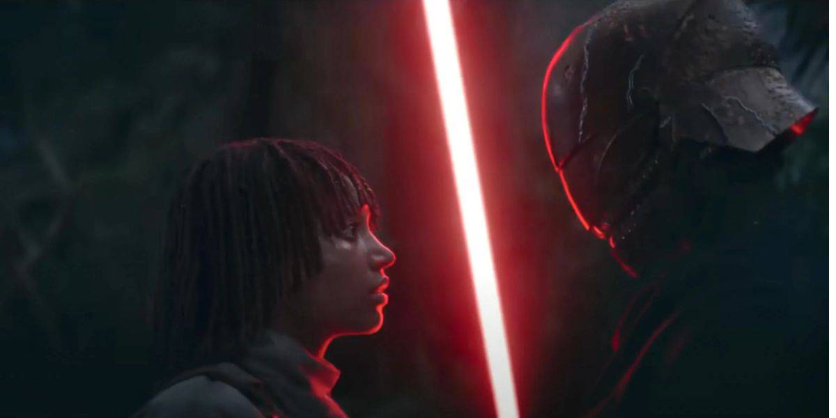 A person with short dreadlocks faces off against a tall figure in a dark helmet. The acolyte's presence adds to the suspense as the scene is dimly lit, with the glow of a red lightsaber illuminating their faces, creating an intense and gripping atmosphere.