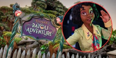 A whimsical sign reads "Tiana's Bayou Adventure" in a forested, Disney theme park setting. A circular inset shows an animated character with dark hair and wearing a yellow top, smiling and waving. The character is overlaid on the right side of the image.