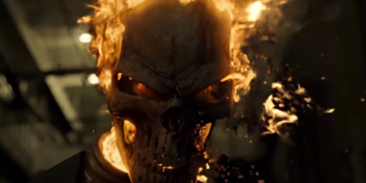 A menacing skeletal figure with a flaming skull glows intensely in a dark setting. The flames engulf the head, emitting a bright light that contrasts starkly with the background, creating an ominous and powerful visual.