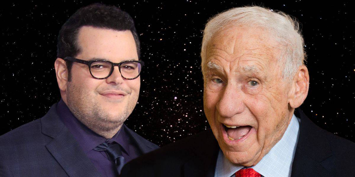 Two men are featured against a starry background reminiscent of Spaceballs. The man on the left wears glasses, a suit, and a tie, and has dark hair. The man on the right has white hair, is wearing a suit and red tie, and is smiling energetically with his mouth open.