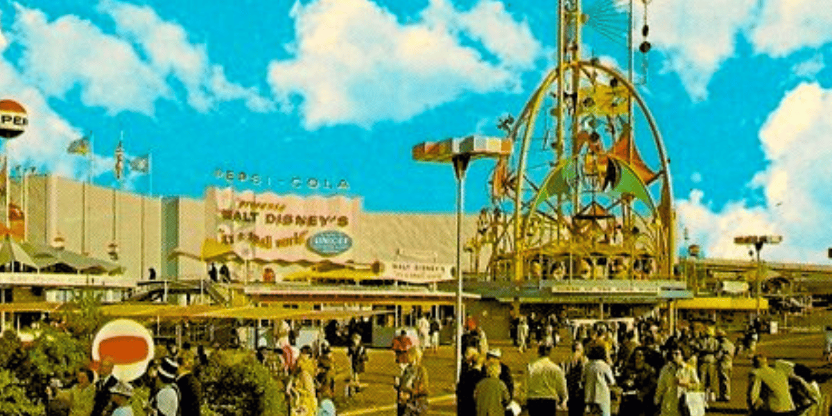 A busy amusement park scene with numerous visitors walking and gathering around. In the background, a large Pepsi-Cola sign is visible above a building that advertises Disneyland attractions. Various rides and colorful structures are present, showcasing the strategic partnerships involved. The sky is bright blue with fluffy clouds.