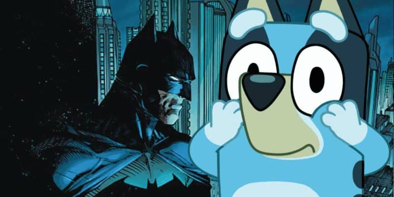 An illustration featuring Batman in a dark cityscape with tall buildings in the background. In the foreground, Bluey, the blue cartoon dog, appears with a surprised expression. The juxtaposition of Batman and Bluey creates a humorous and contrasting scene.