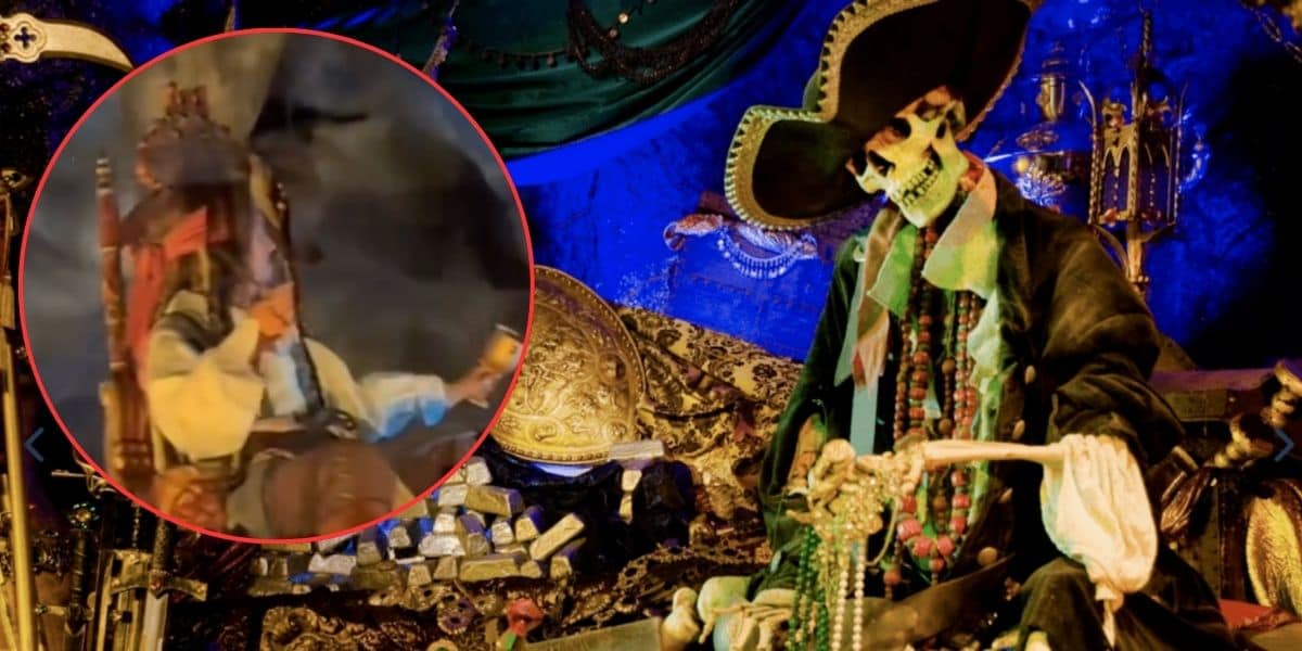 A pirate-themed display featuring a skeleton dressed in pirate attire, seated among treasure chests and gold coins. The background is adorned with blue and green fabrics. There is an inset image of a costumed pirate drinking from a mug.