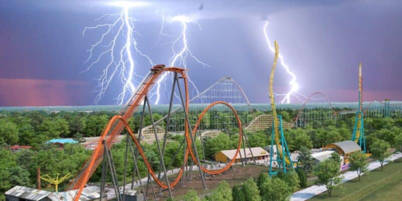 An amusement park with various roller coasters and attractions is shown. Lightning bolts dramatically light up the sky during a storm, creating a striking contrast with the vibrant colors of the rides and lush greenery. Due to the devastating weather conditions, this 140-year-old theme park suspends all operations.