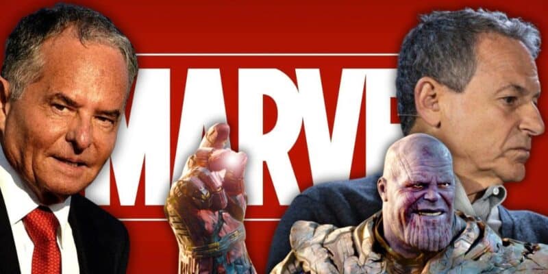 Two men in suits are positioned on either side of the Marvel logo. The man on the left is holding up his hand with a glowing gem, reminiscent of Thanos from the Marvel universe, who is shown below them. The man on the right seems to be looking away. The red background evokes classic Disney flair.