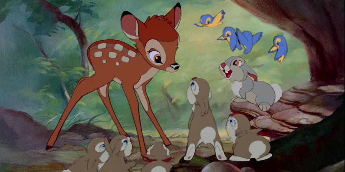 An animated scene featuring a young deer standing in a forest, surrounded by five rabbits, with a laughing rabbit among them. Three blue birds are flying overhead. Vivid greenery and a tree stump are visible in the background.