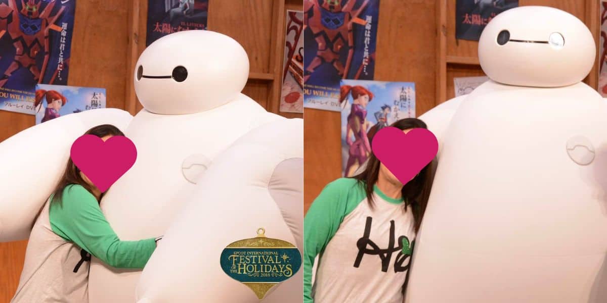 A person with a pink heart covering their face is hugging a large, white, inflated Baymax character. The background has wooden panels and various posters. At the bottom, a logo reads "Disney Festival of Holidays." The person is wearing a green and white baseball-style shirt.