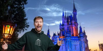 MrBeast stands in front of a brightly lit Disney castle, appearing excited with arms outstretched.