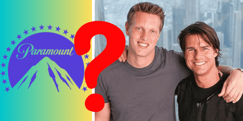 Two individuals stand side by side, smiling at the camera. A large red question mark is placed over them. To the left, there is a Paramount logo featuring a mountain with stars. The background reveals a cityscape visible through windows, hinting at an entertainment giant's major deal sealed this weekend.