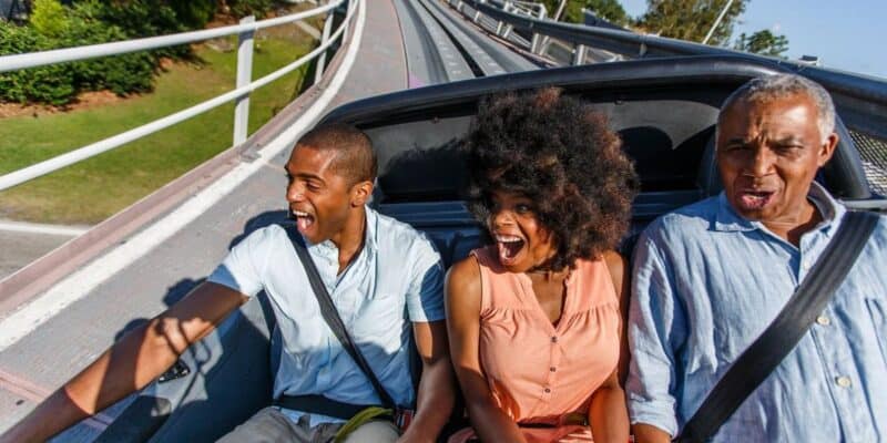 Three people in the back row of Test Track, a Disney World ride in EPCOT.
