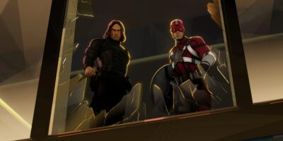 An illustration of two comic action characters standing in a broken window frame. The character on the left wears dark armor and has long hair, while the character on the right wears a red helmet and a red and grey armored suit.