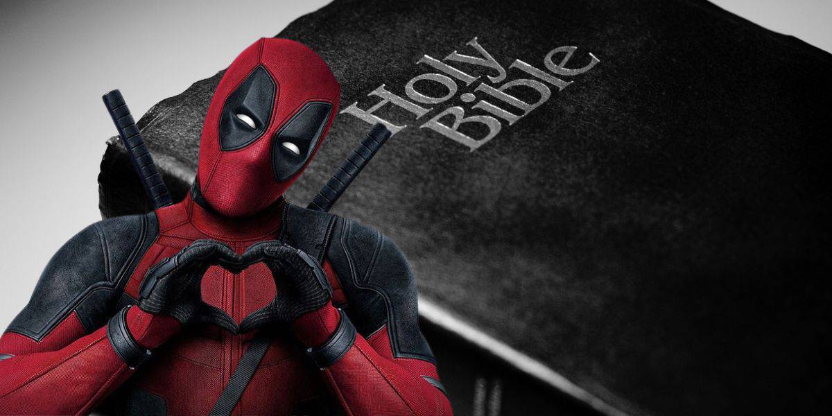 A character in a red and black costume with a mask, resembling Deadpool, is making a heart shape with his hands. In the background, there is a close-up of a book cover with the text "Holy Bible" visible, which some Christians might find controversial.