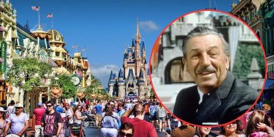 A bustling crowd fills Main Street, U.S.A. at a theme park, leading up to a majestic castle in the background. A large, circular inset on the right side of the image features an older man with a mustache, smiling, dressed in a suit.