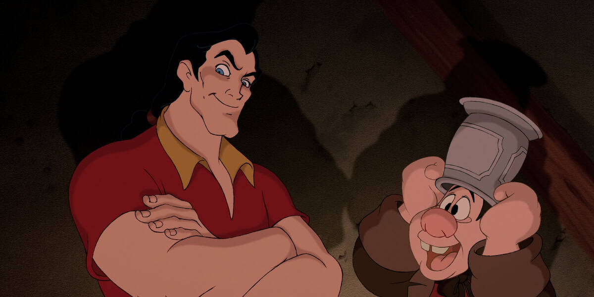 A muscular man with long hair and a confident expression wearing a red shirt stands next to a shorter, cheerful man holding a mug on his head. The taller man's arms are crossed while the shorter man smiles widely, both characters are set against a dimly lit background.