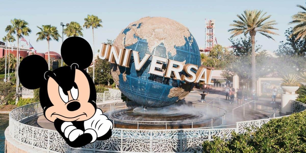 Mickey Mouse looks annoyed next to the Universal Orlando Resort globe.