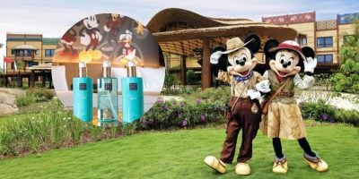 Mickey and Minnie stand outside Disney Explorers Lodge with Rituals products in a circle to the left of them.