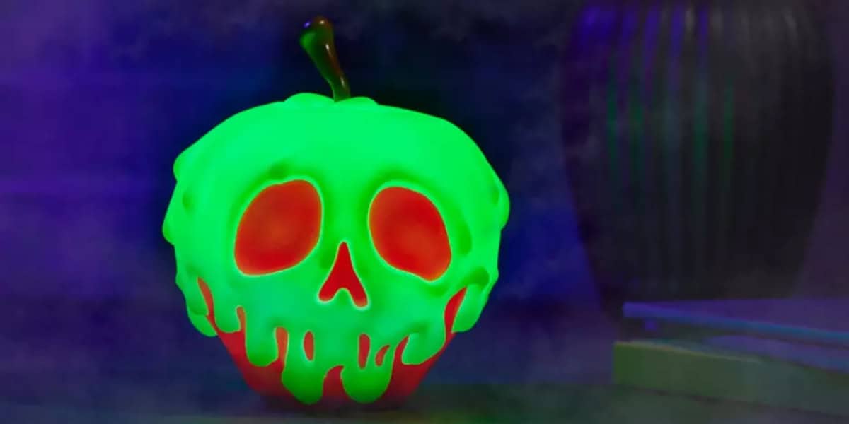 A glowing green apple with a red skull design on its front. The apple appears to be dripping, creating a spooky, eerie effect. The background is dark and foggy, adding to the ominous atmosphere.