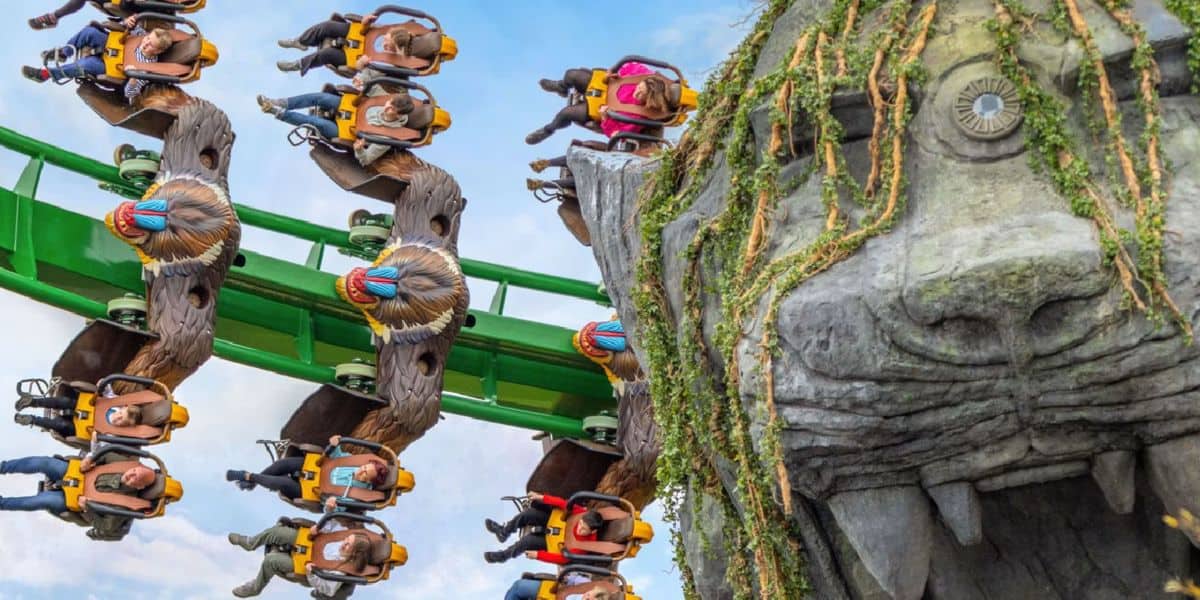 A roller coaster filled with people twists upside-down on a track at Chessington World of Adventures.