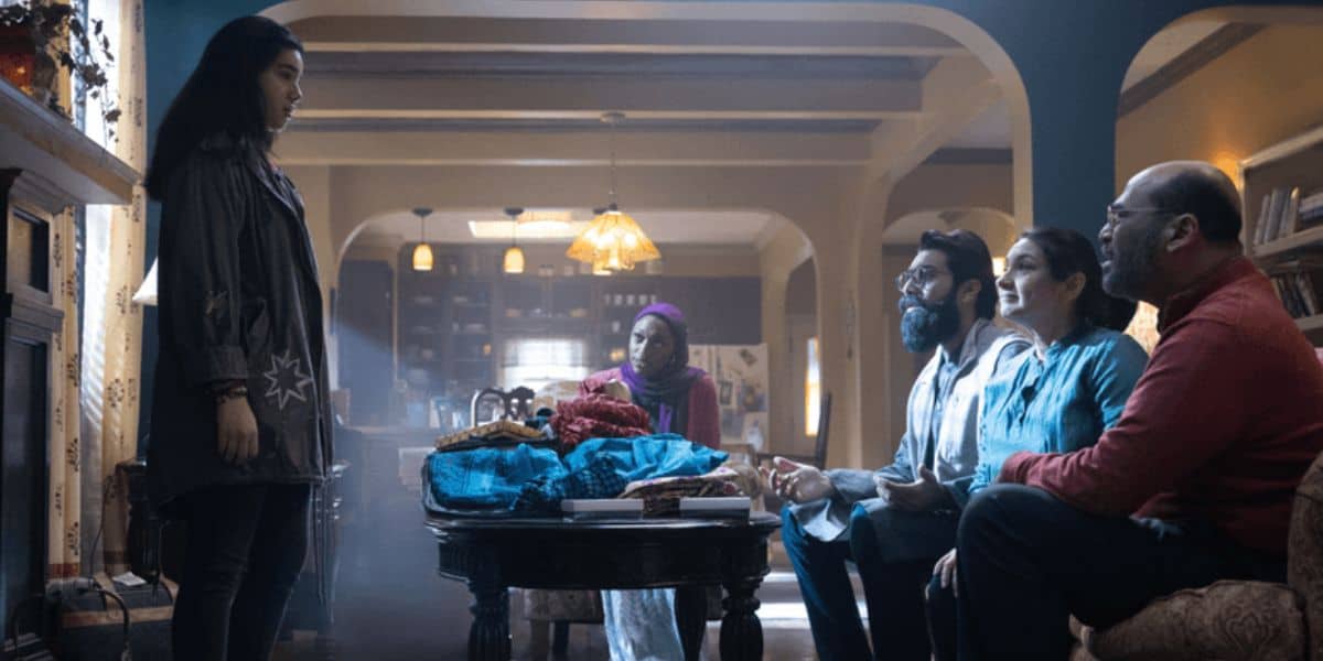 Kamala Khan (Iman Vellani) faces her family on the couch, including Yusuf Khan (Mohan Kapur).