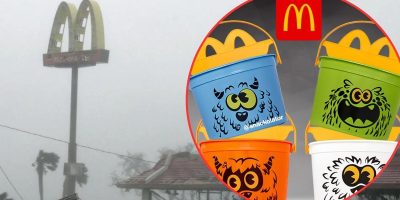 A foggy scene shows the iconic McDonald's golden arches in the background. The foreground features a circular inset with three viral Halloween-themed McDonald's Happy Meal buckets: blue with a monster face, green with a scary face, and white with a furry creature face. These collectibles could break the internet!